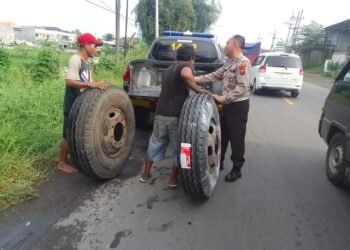 Polisi Gresik Sigap Bantu Sopir Truk Ganti Ban Atasi Kemacetan di Jalan Raya Mojotengah Menganti