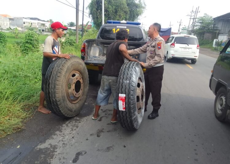 Polisi Gresik Sigap Bantu Sopir Truk Ganti Ban Atasi Kemacetan di Jalan Raya Mojotengah Menganti