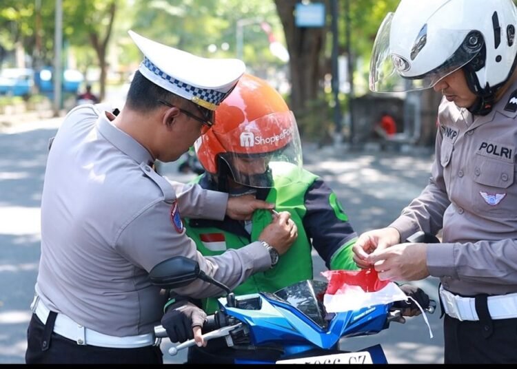 Kobarkan Semangat Kemerdekaan, Satlantas Polres Gresik Bagikan Bendera dan Pin Merah Putih di Simpang Empat GKB