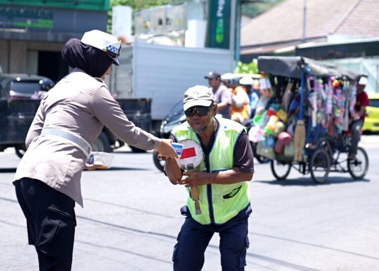 Meski Cuaca Panas Ekstrem, Satlantas Polres Gresik Penuh Semangat Bagikan Makanan di Jalan Raya