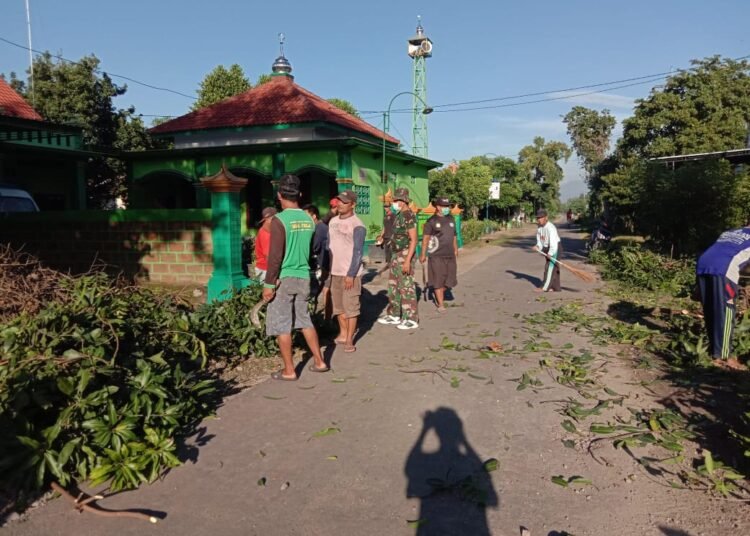 Babinsa Dukun Bersama Warga Gotong Royong Pangkas Ranting Pohon yang Bahayakan Pengguna Jalan