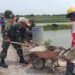Tak Kenal Libur, Babinsa Koramil Cerme Bantu Warga Bangun Dinding Penahan Jalan