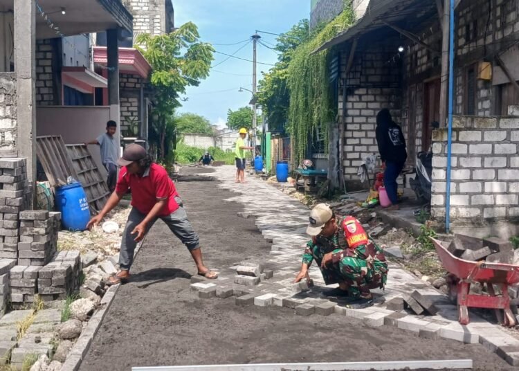 Puasa Ramadan, Babinsa Manyar Tetap Semangat Bantu Warga Pasang Paving di Desa Peganden
