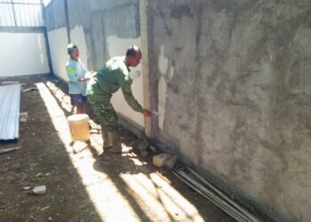 Kejar Target KDKMP, Babinsa Balongpanggang Turun Tangan Bantu Plamir Tembok