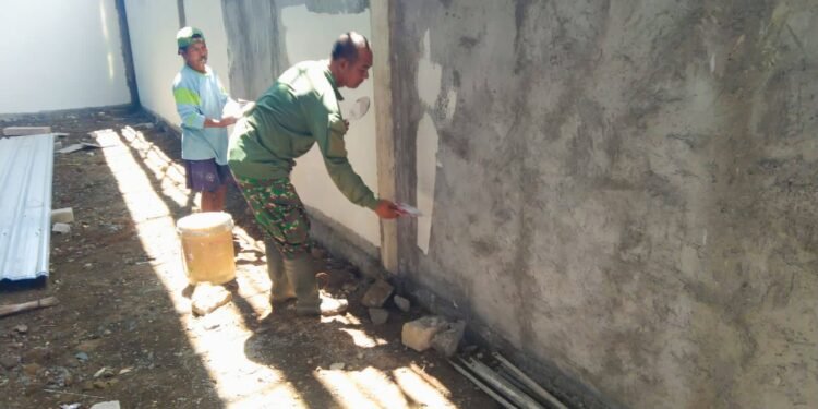 Kejar Target KDKMP, Babinsa Balongpanggang Turun Tangan Bantu Plamir Tembok