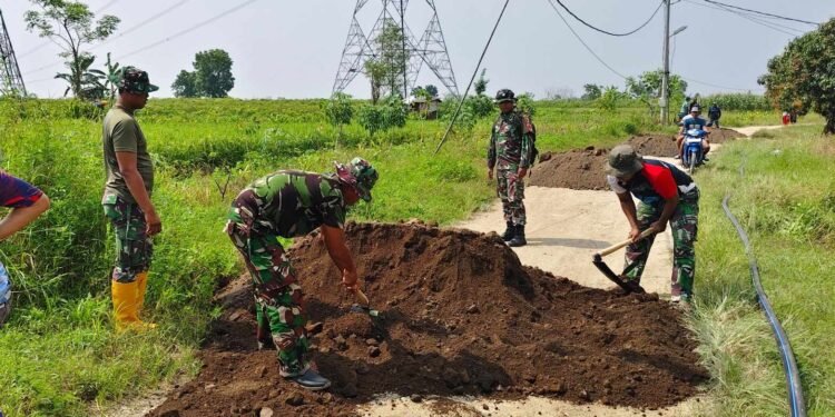 Kerja Keras Satgas TMMD ke-128 Gotong Royong Bersama Warga Perbaiki Jalan Poros Desa