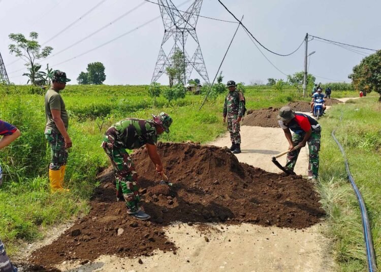 Kerja Keras Satgas TMMD ke-128 Gotong Royong Bersama Warga Perbaiki Jalan Poros Desa